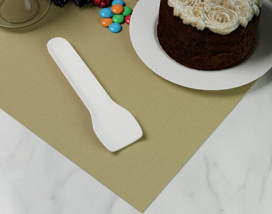 Paper ice cream spoon beside a cake